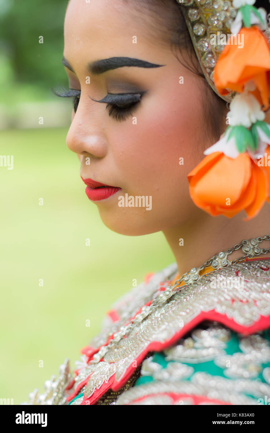 Portrait of Thai young lady wearing Thai traditional dress in the garden Stock Photo