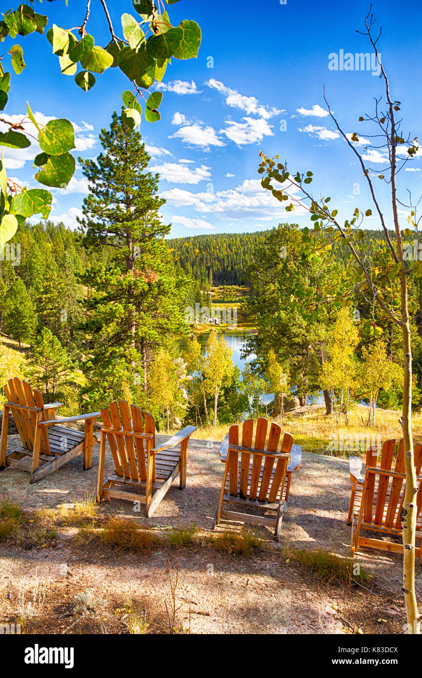 Adirondack Chairs Arainged On A Rock Overlooking A Mountain