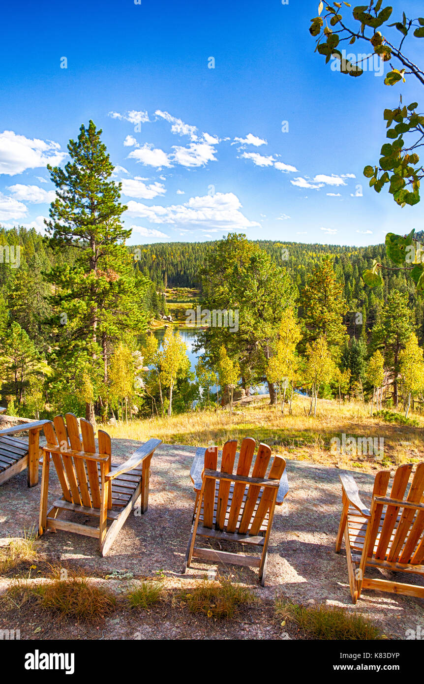 Adirondack Chairs Arainged On A Rock Overlooking A Mountain