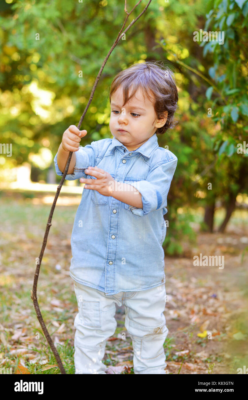 https://c8.alamy.com/comp/K83GTN/adorable-one-year-old-playing-with-wooden-branch-K83GTN.jpg
