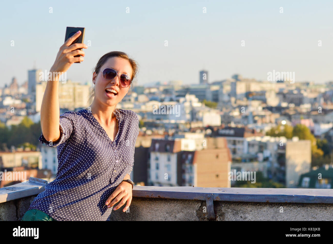 Girl taking a selfie at the rooftop with view at city of Belgrade Stock Photo