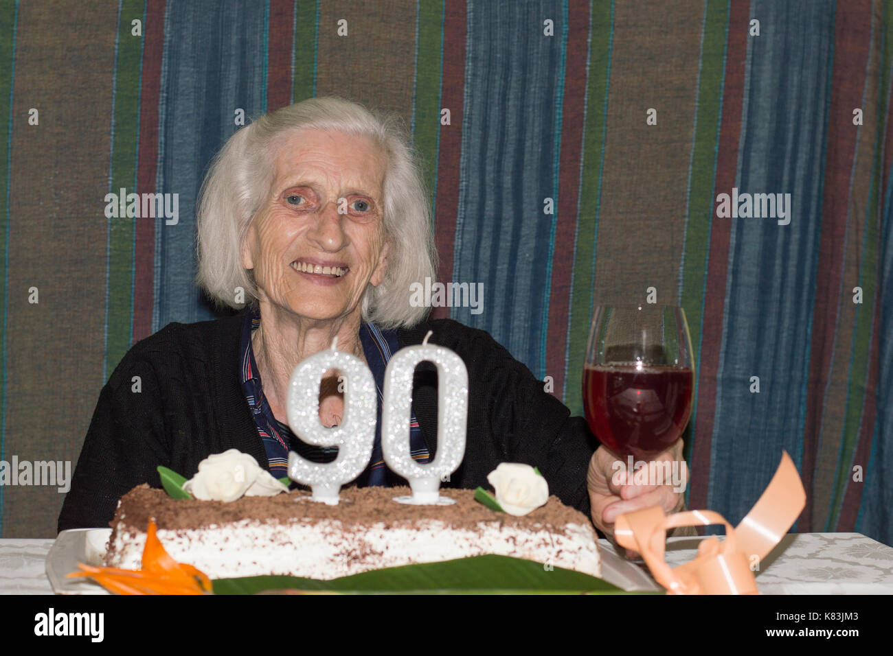 Grandma celebrating her 90th birthday with some red wine Stock Photo