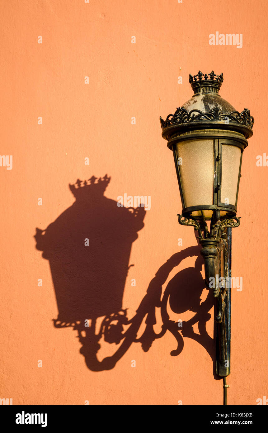 Cast irons street light casting a shadow on a Mediterranean old town