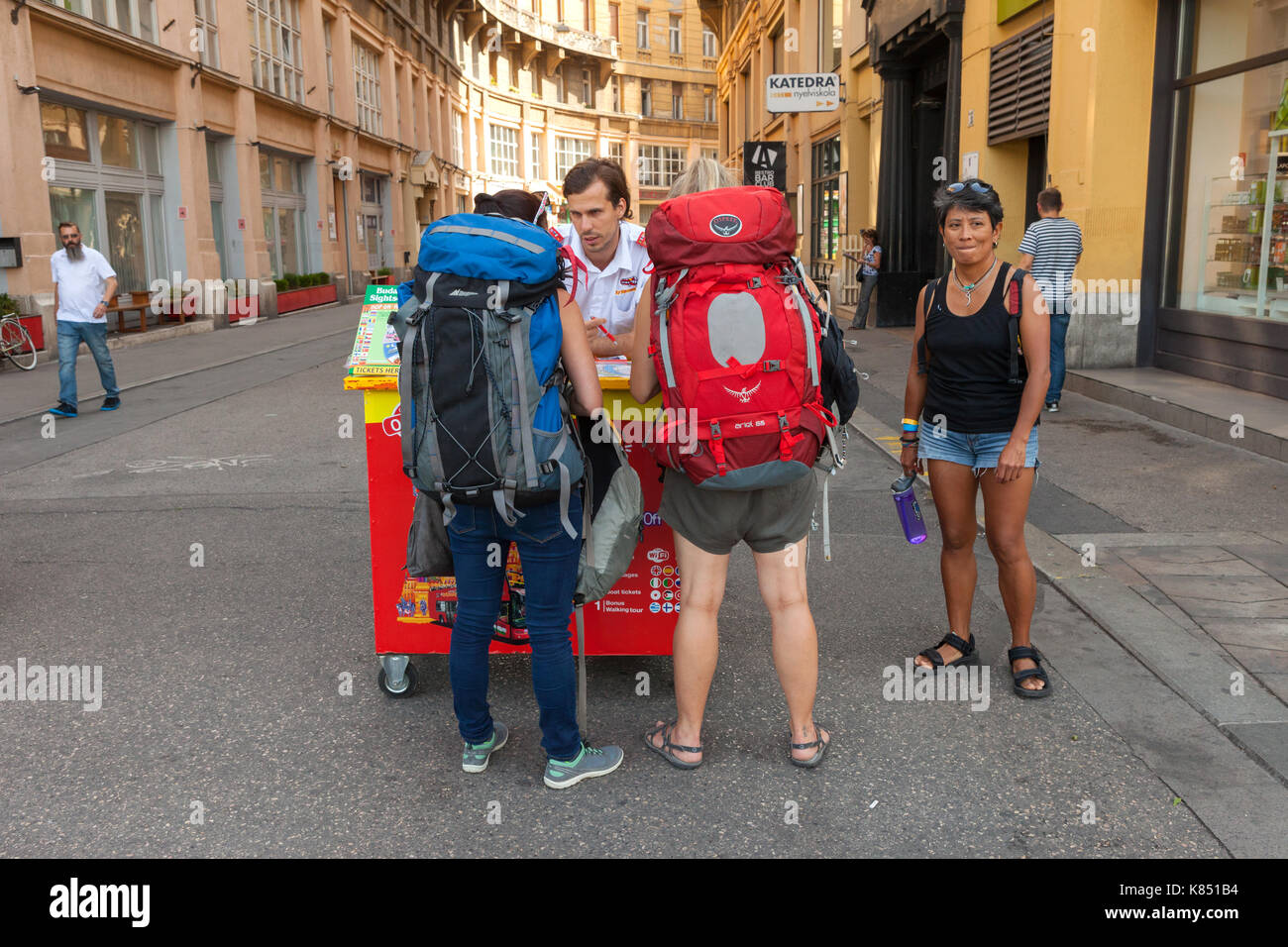 Backpackers at a city guide tour stand in central Budapest, checkin out optional tours. Stock Photo