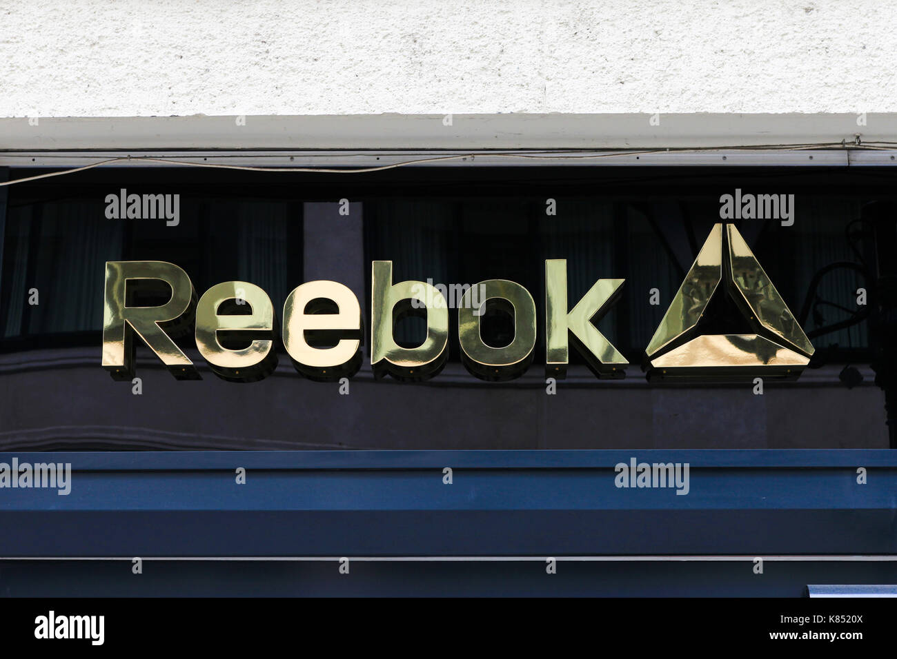 Reebok logo on a building. Reebok is a global athletic footwear and apparel company. Reebok produces and distributes fitness, running and CrossFit spo Stock Photo