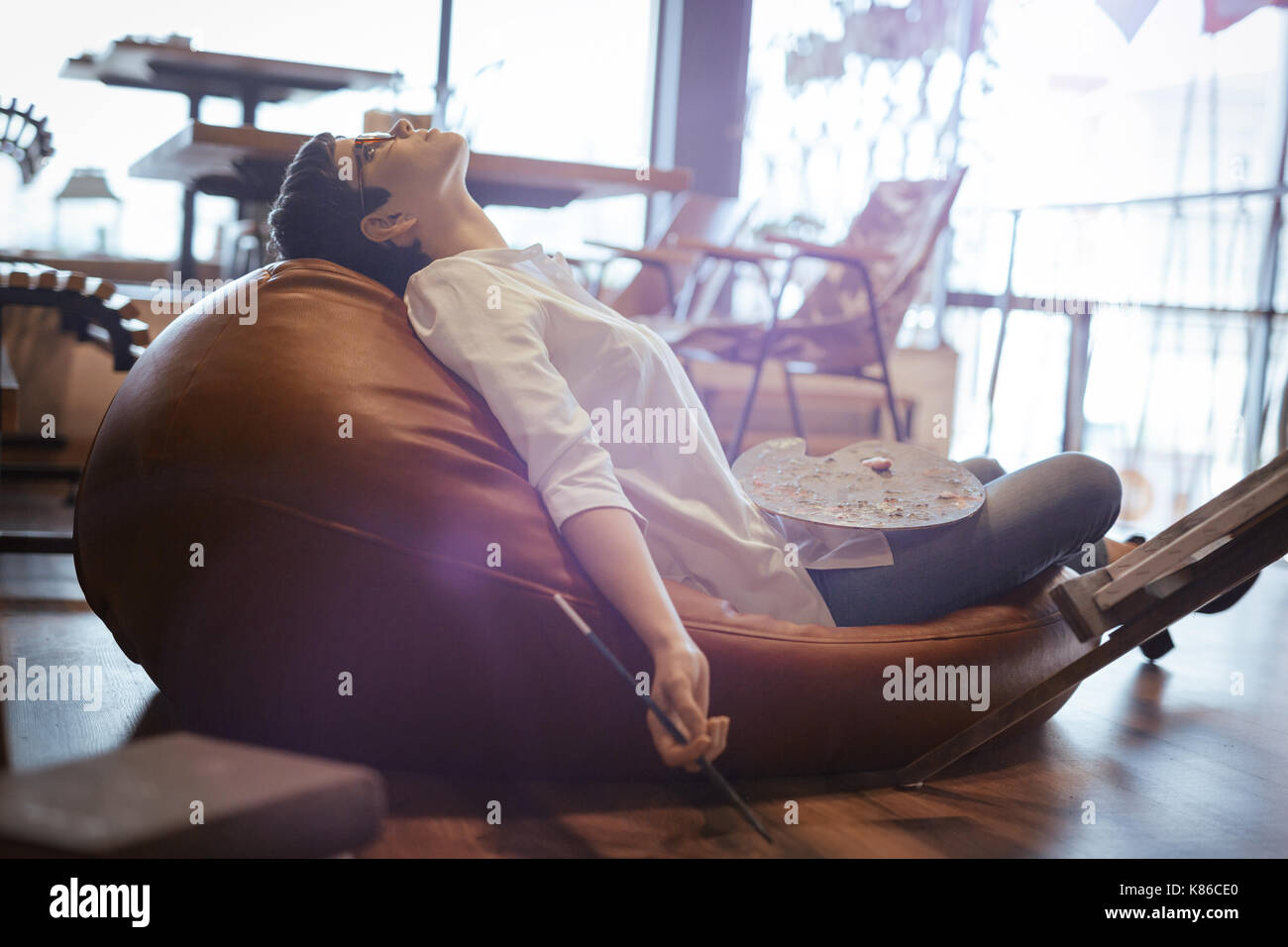 Tried overworked female artist sleeping while working Stock Photo