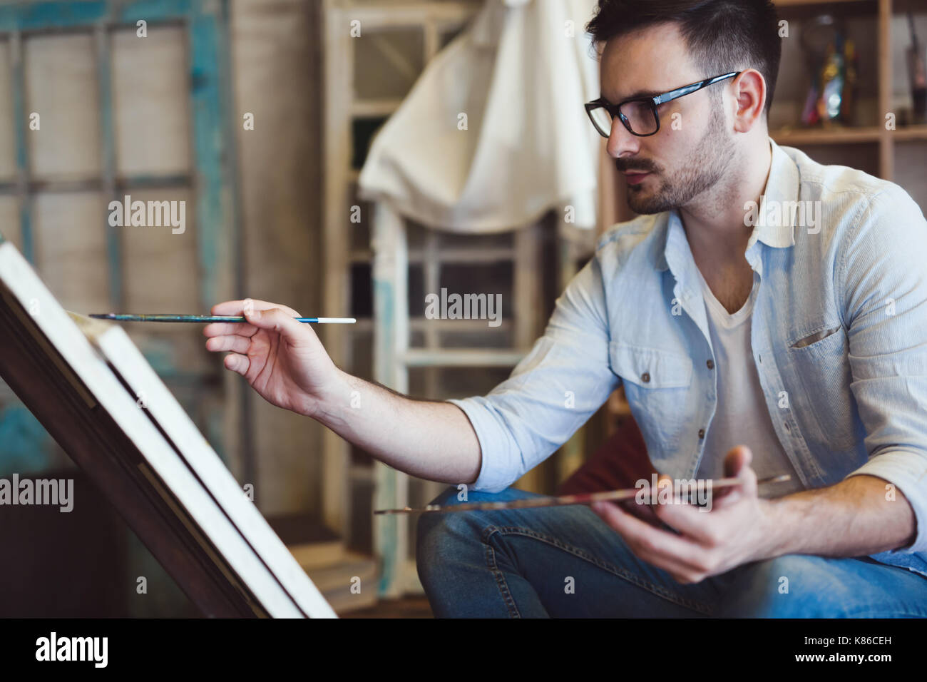 Young happy male artist painting hi-res stock photography and images ...
