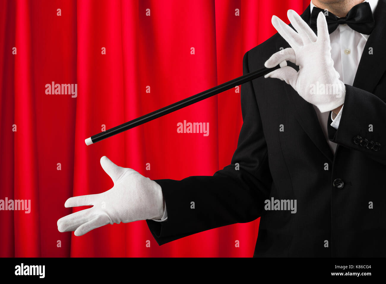 Closeup Of Magician In Suit Showing Trick With Magic Wand Stock Photo