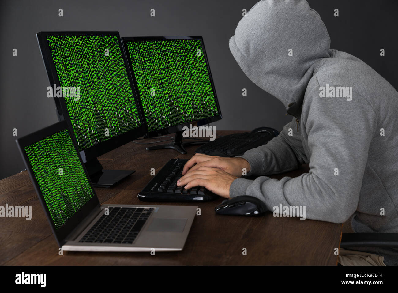 Hacker Typing On Computers With Binary Code At Desk Stock Photo - Alamy
