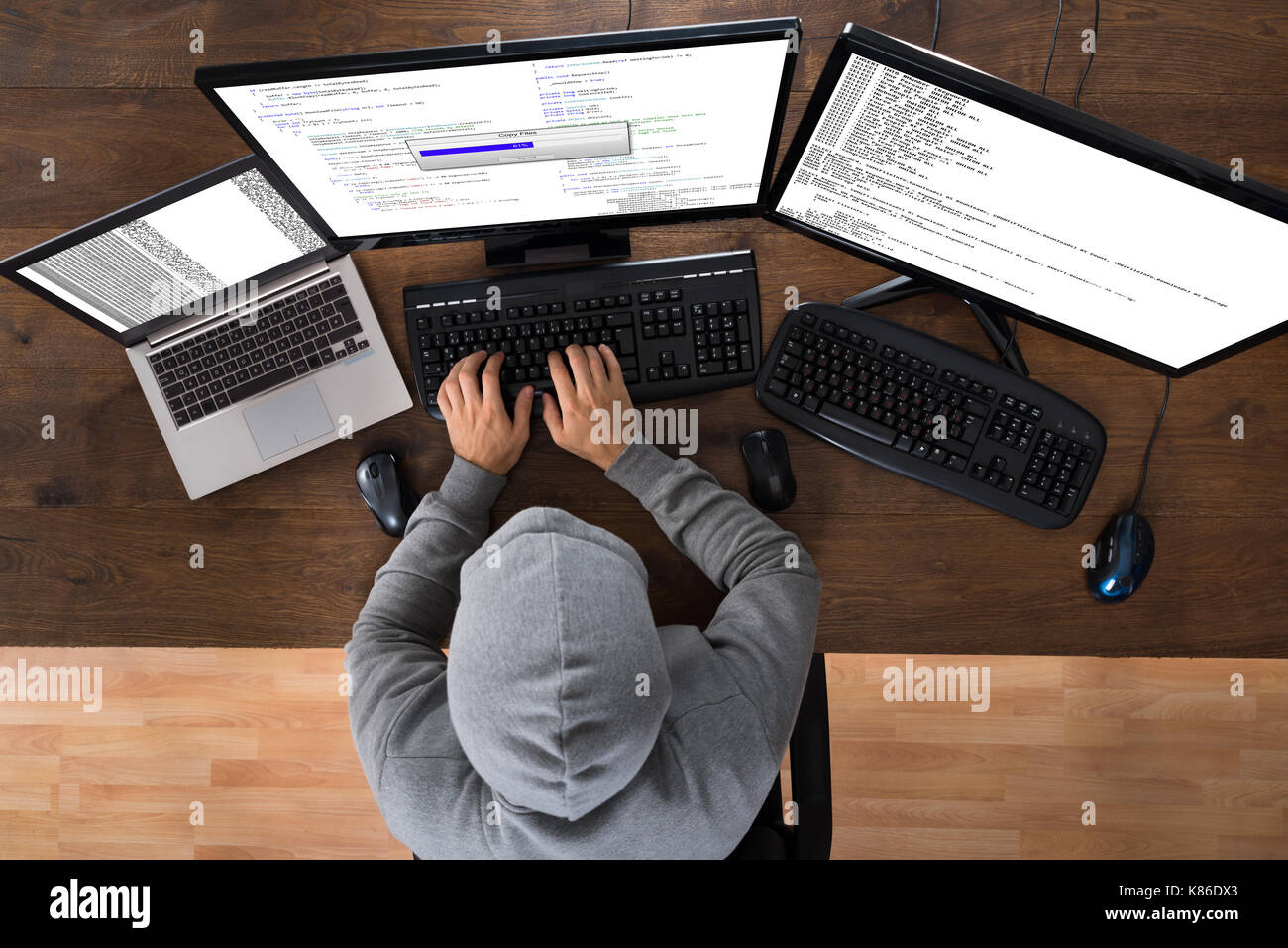 High Angle View Of Hacker Stealing Information From Computers At Desk Stock Photo