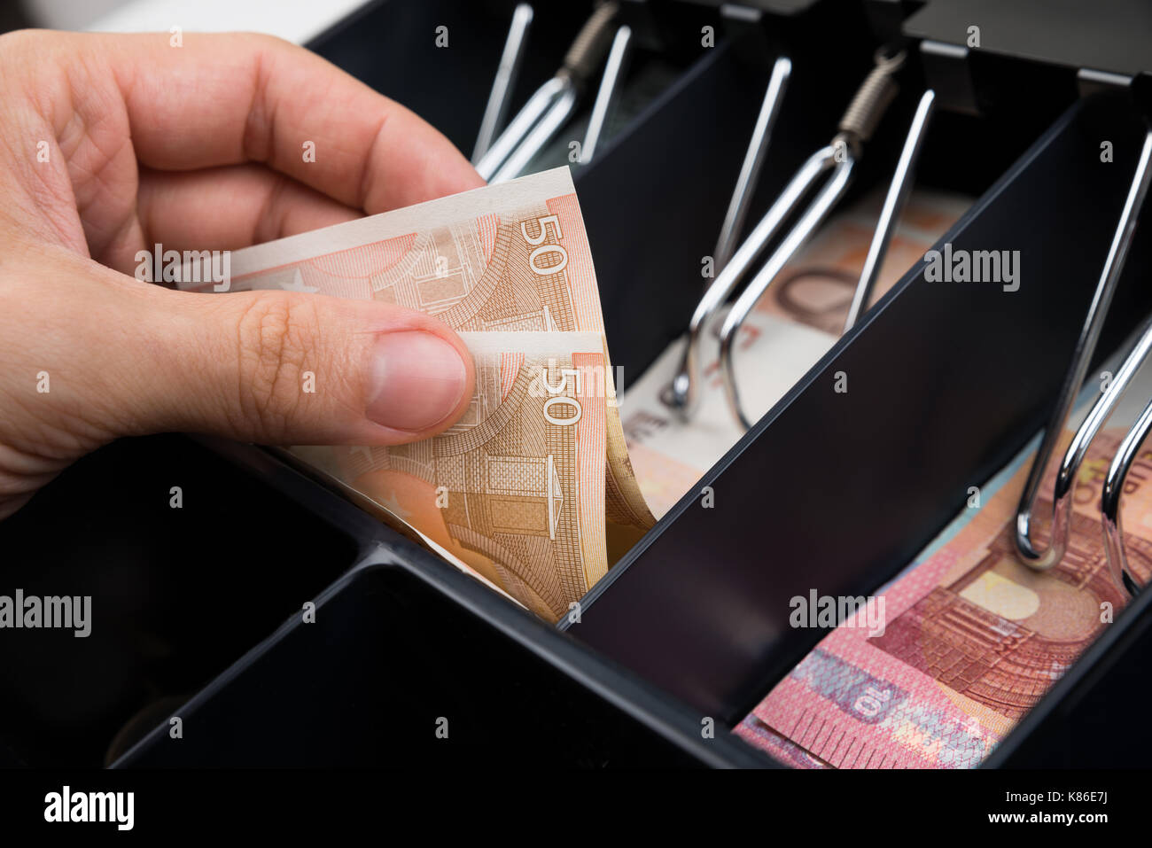 Close-up Of Person Hands With Money Over Cash Register Stock Photo