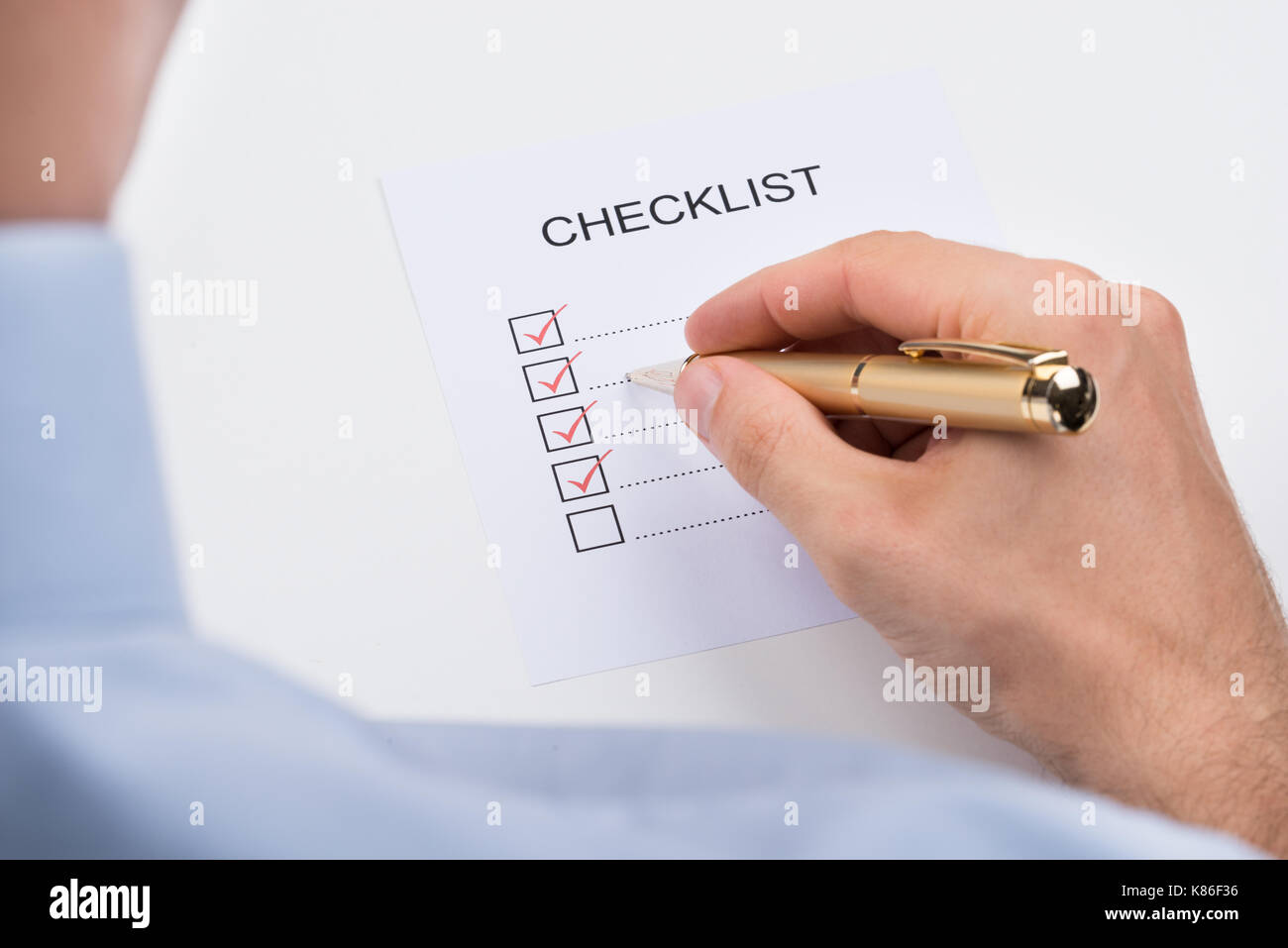 Close-up Of Person Filling Checklist Form With Pen Stock Photo