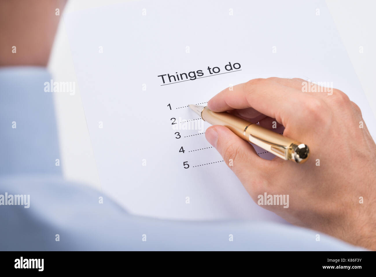 Close-up Of Businessperson Hands Writing Things To Do On Paper Stock Photo
