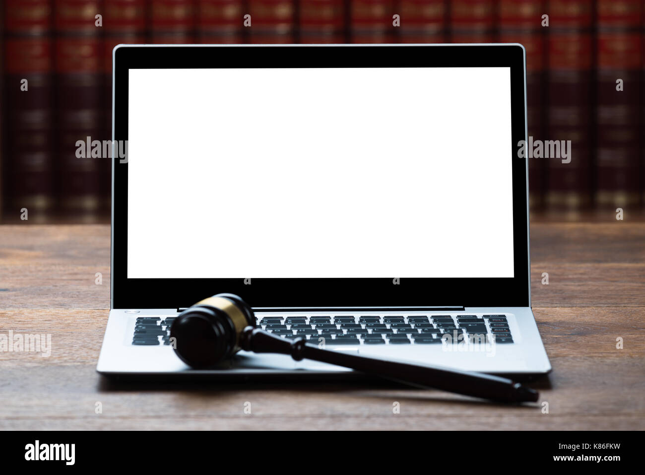 Closeup of laptop and mallet on table in courtroom Stock Photo