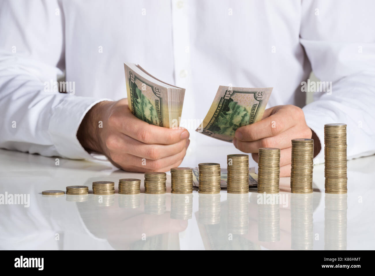 Midsection of businessman counting money at office desk Stock Photo Alamy