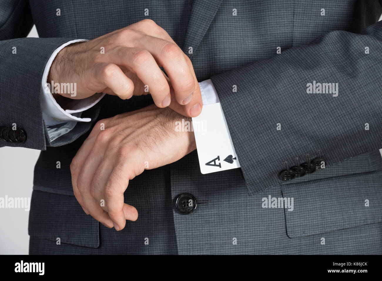 Midsection of businessman removing ace cards from sleeve in office Stock Photo