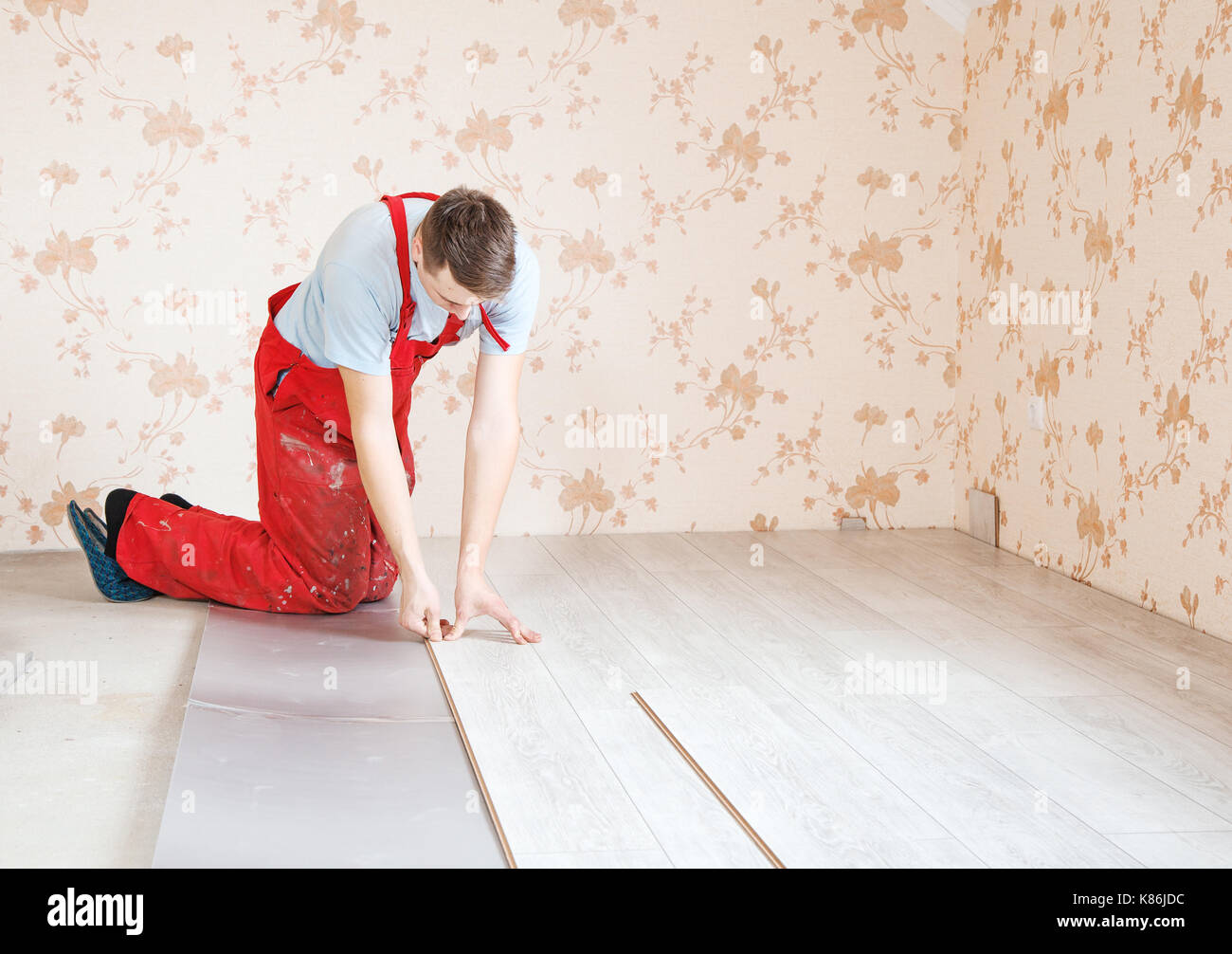 Handyman Laying Down Laminate Flooring Boards While Renovating A