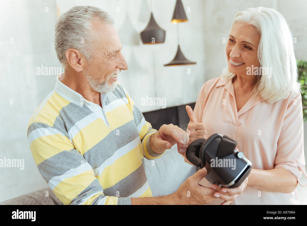 Positive retired couple holding VR glasses Stock Photo