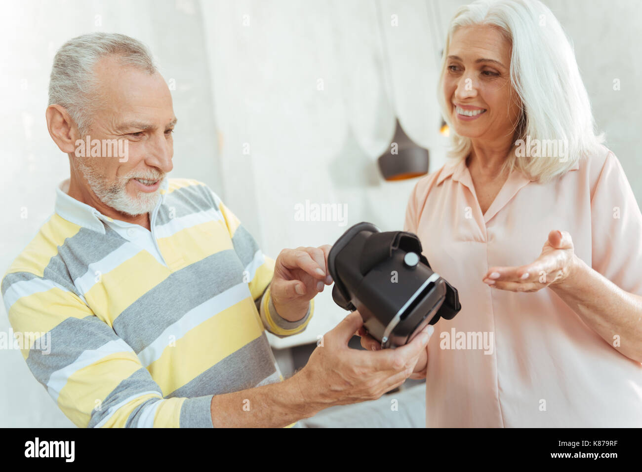 Positive aged coupel holding virtual reality glasses Stock Photo