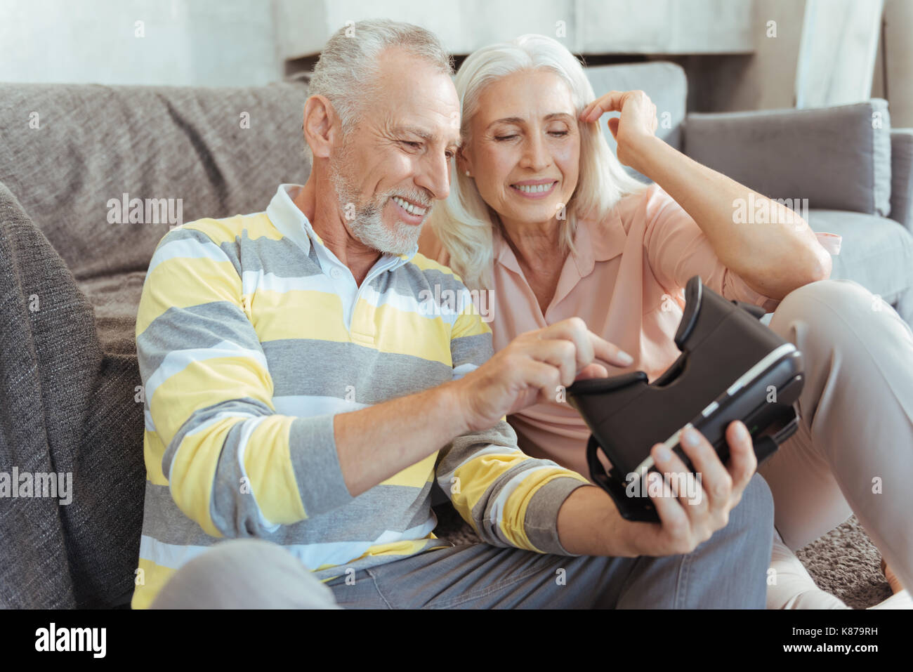 Positive aged couple trying up virtual reality device Stock Photo