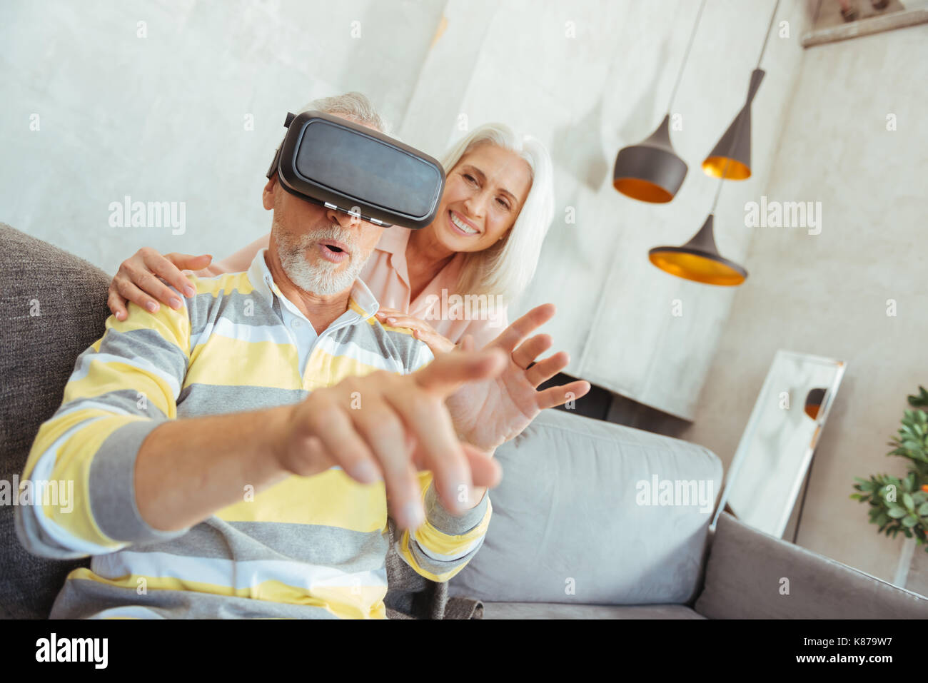 Retired aged man trying up VR glasses Stock Photo