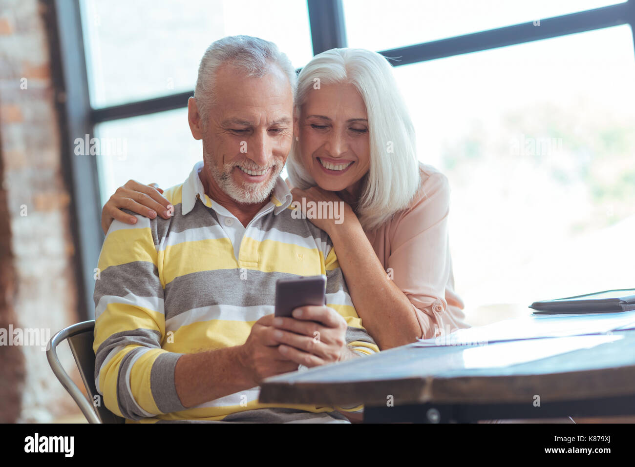 Positive aged couple using their smart phone Stock Photo