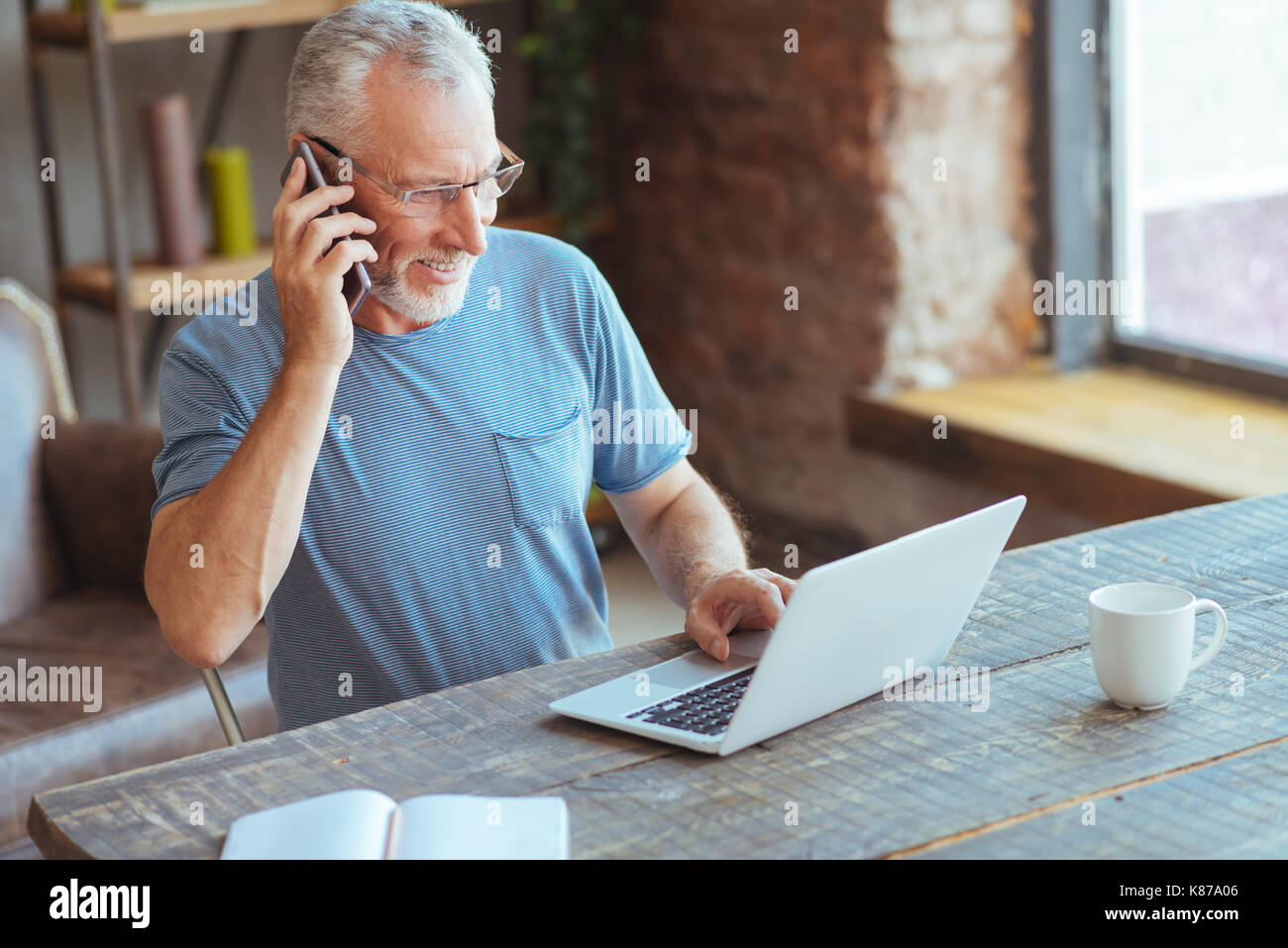 Joyful elderly man talking on phone Stock Photo