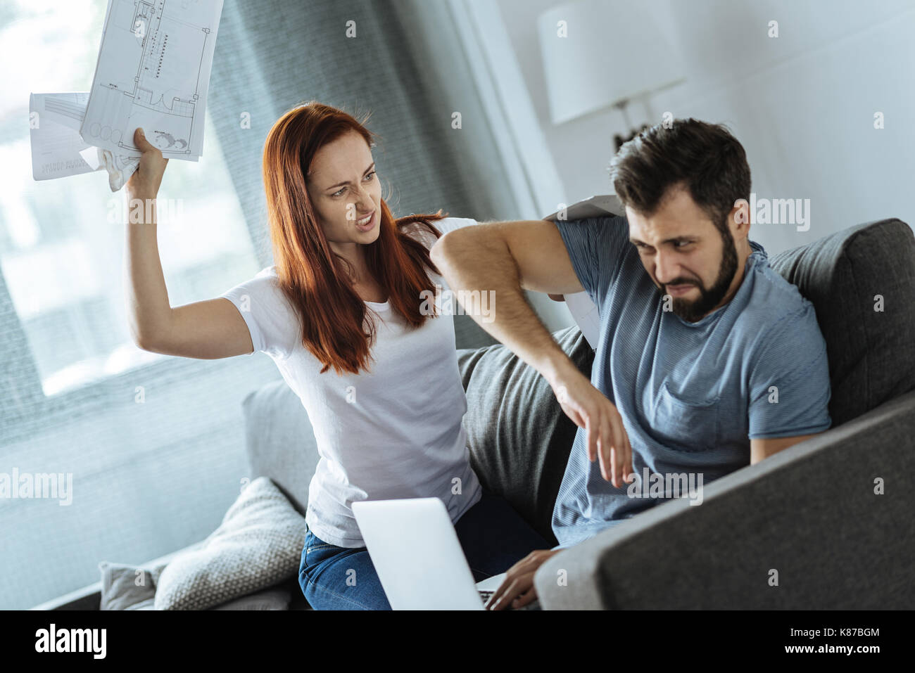 Furious red haired woman being angry at her boyfriend Stock Photo