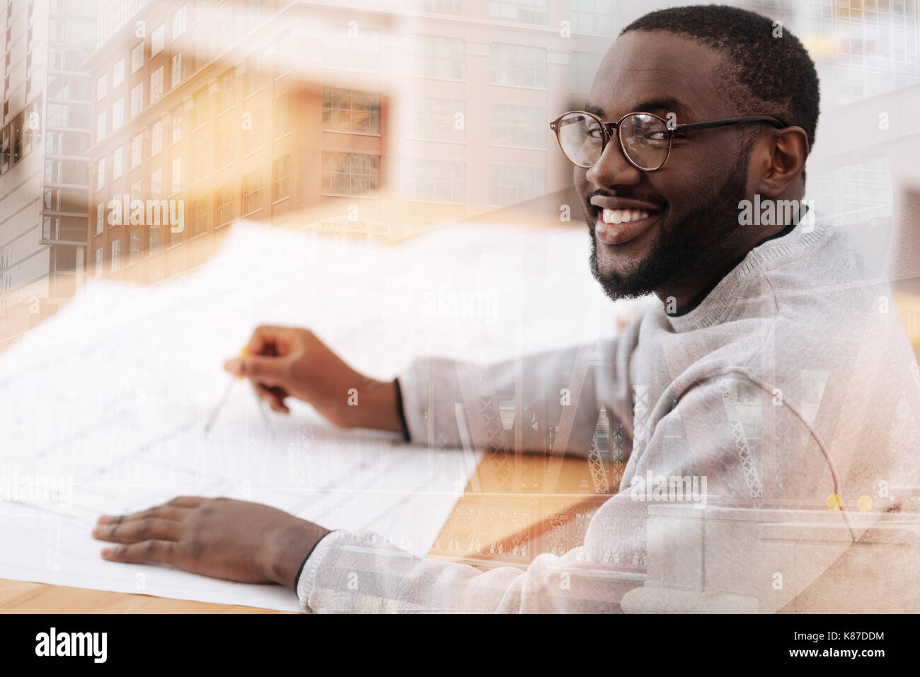 Smiling hardworking man sitting at the table Stock Photo