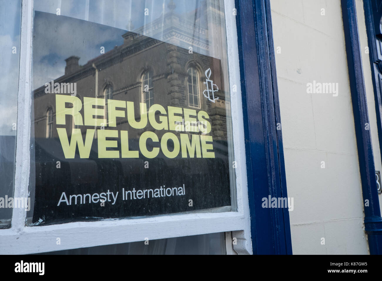 Refugees,welcome,poster,published,by,Amnesty International,displayed,in,window,of,house,in,centre,of,Aberystwyth,Mid,West,Wales,Welsh,immigration,UK, Stock Photo