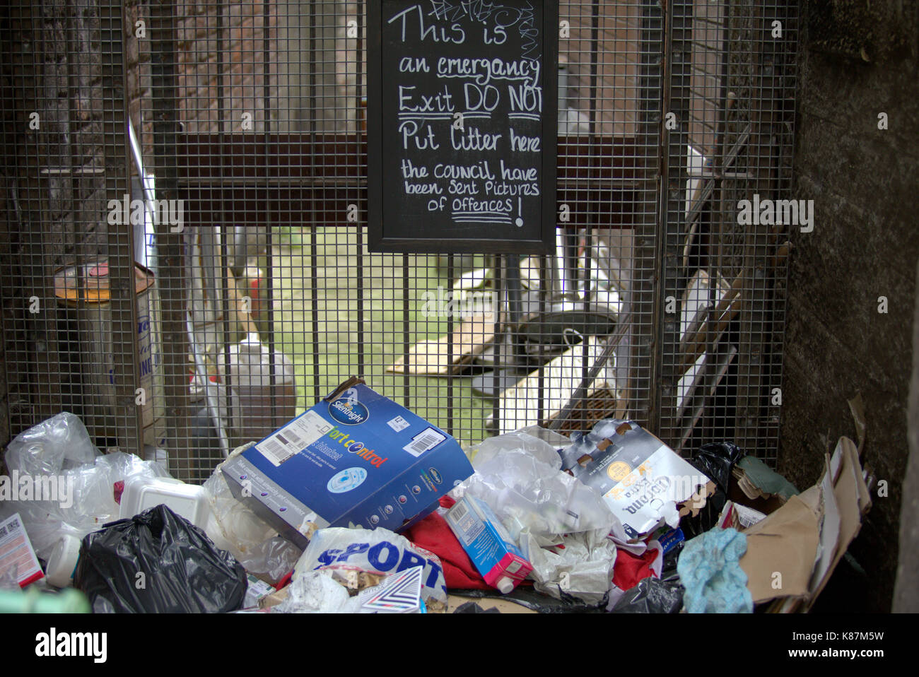 fly tipping rubbish litter blocked entrance sign Stock Photo