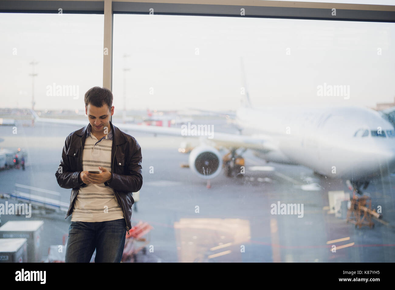 Young business man in airport using smartphone . Stock Photo