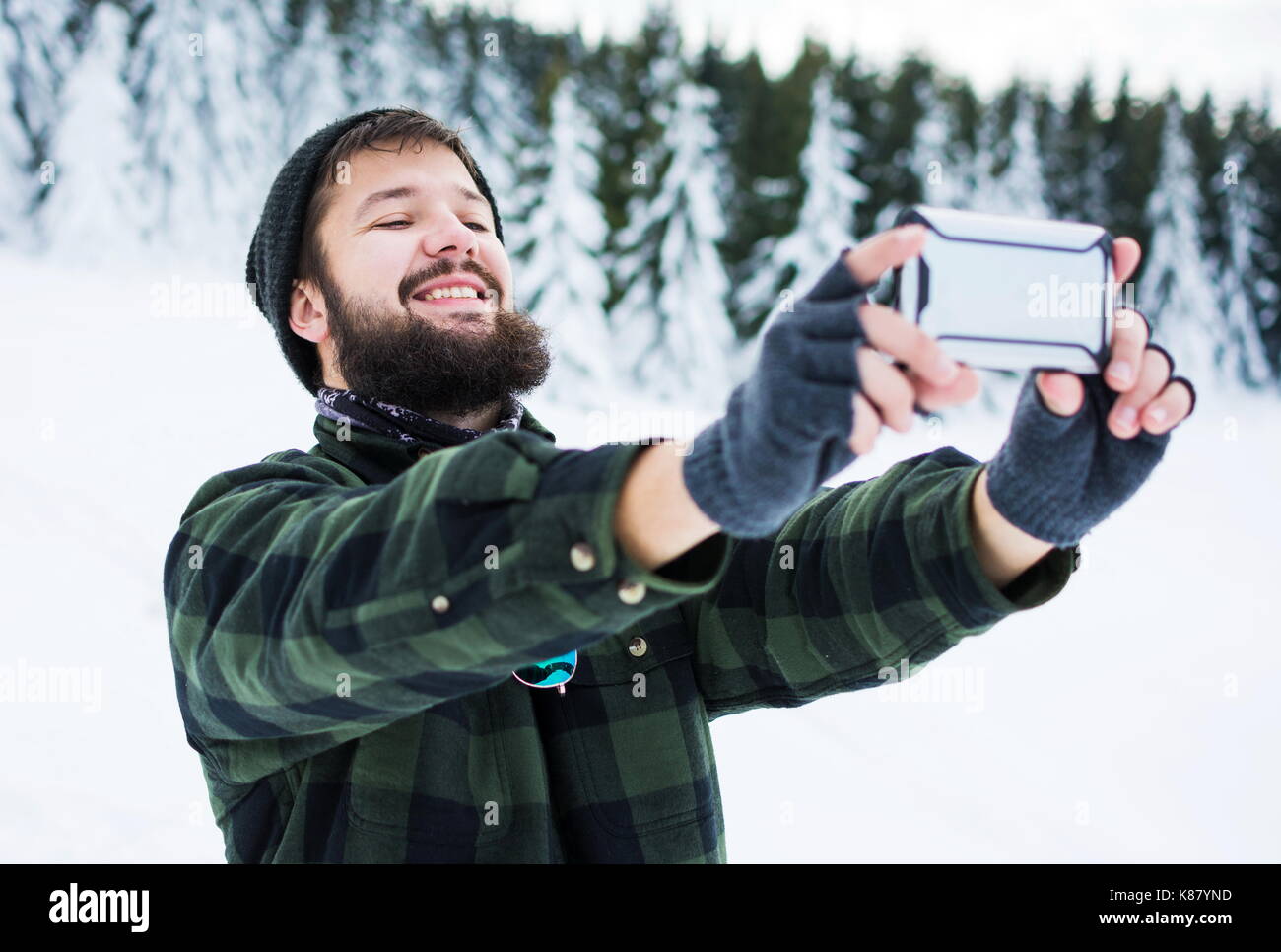Bearded man taking selfie on the snow covered mountain Stock Photo