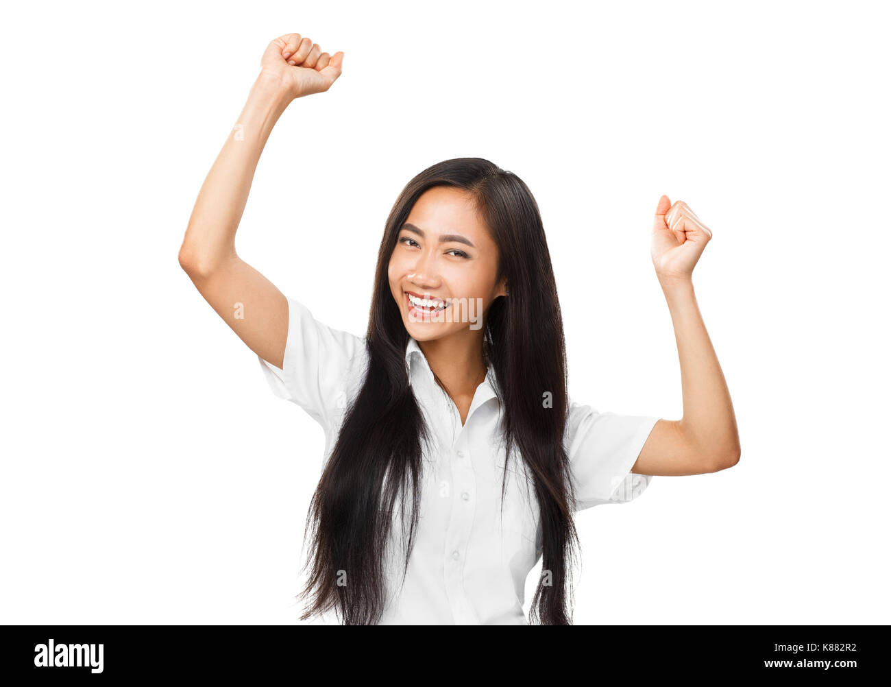 Happy young oriental woman dancing or rejoicing. Portrait of cheerful smiling Asian girl with hands up. Joyful emotions, victory, entertainment concep Stock Photo