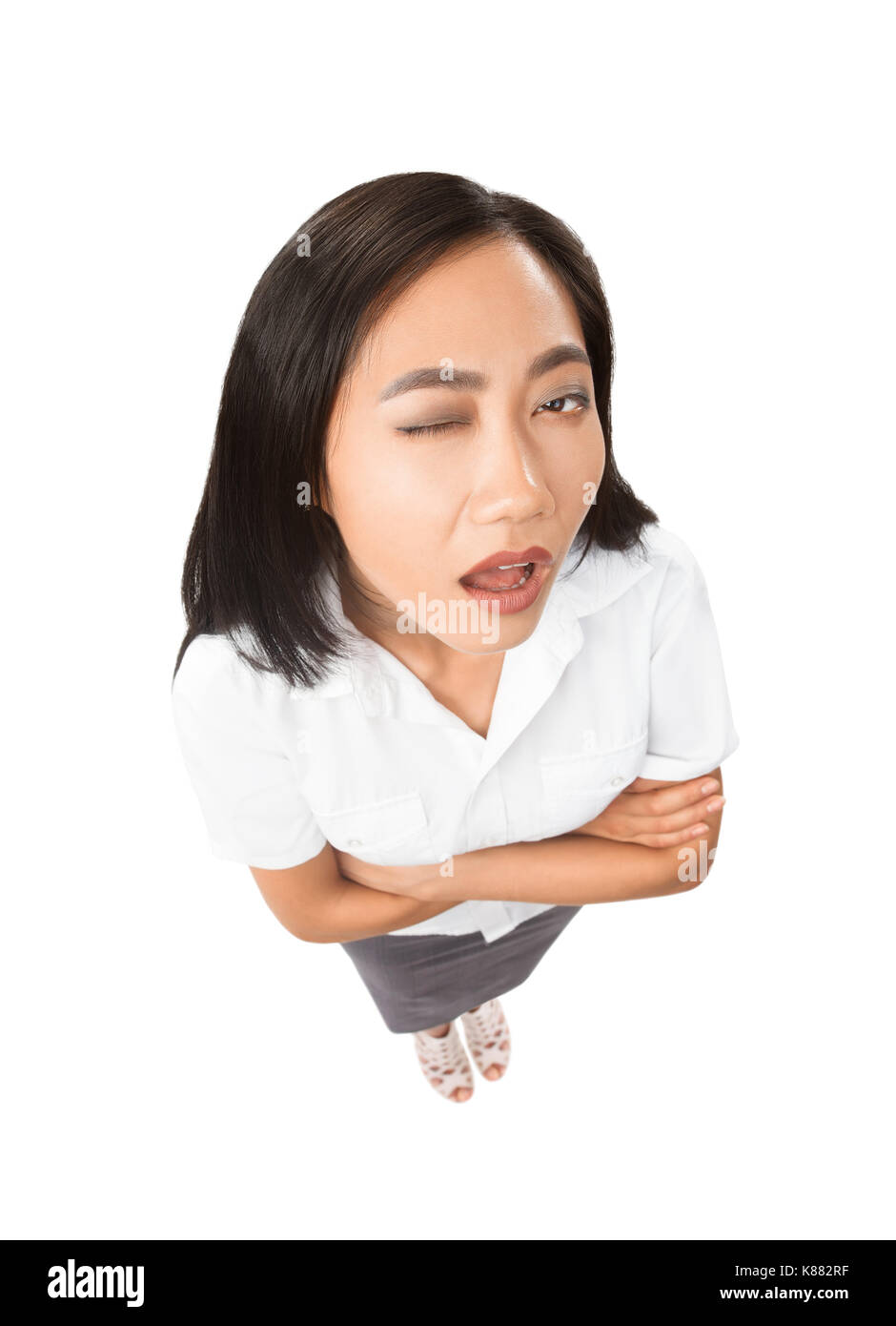 Top view portrait of Asian woman with facial expressions - apathy, fatigue, mannerisms concept. Model in full length with one closed eye and open mout Stock Photo