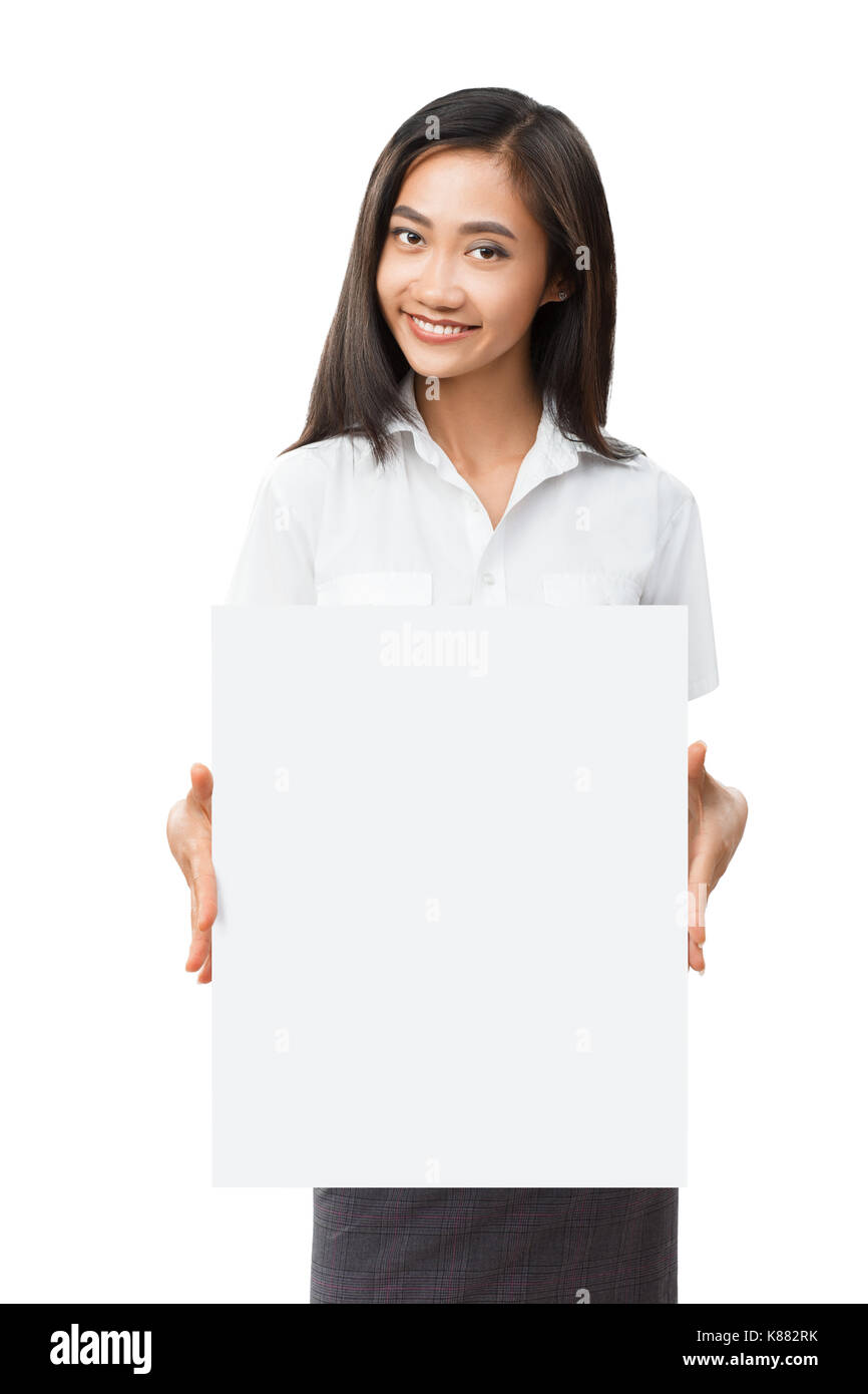 Young smiling Asian woman with blank white sign board. Beautiful businesswoman holding banner with copyspace for advertising messages, posters and tex Stock Photo