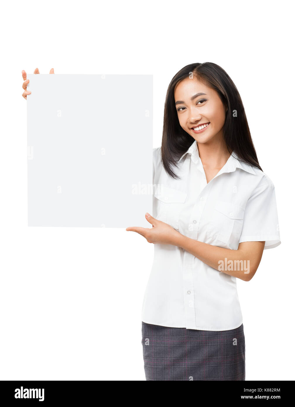 Young smiling Asian woman with blank white sign board. Beautiful businesswoman holding banner with copyspace for advertising messages, posters and tex Stock Photo