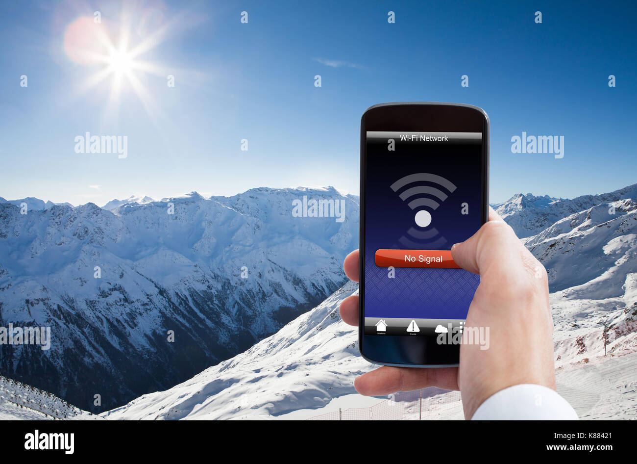 Close-up Of Person Hand With No Wifi Signal On Mobile Phone In Snowy Mountain Stock Photo