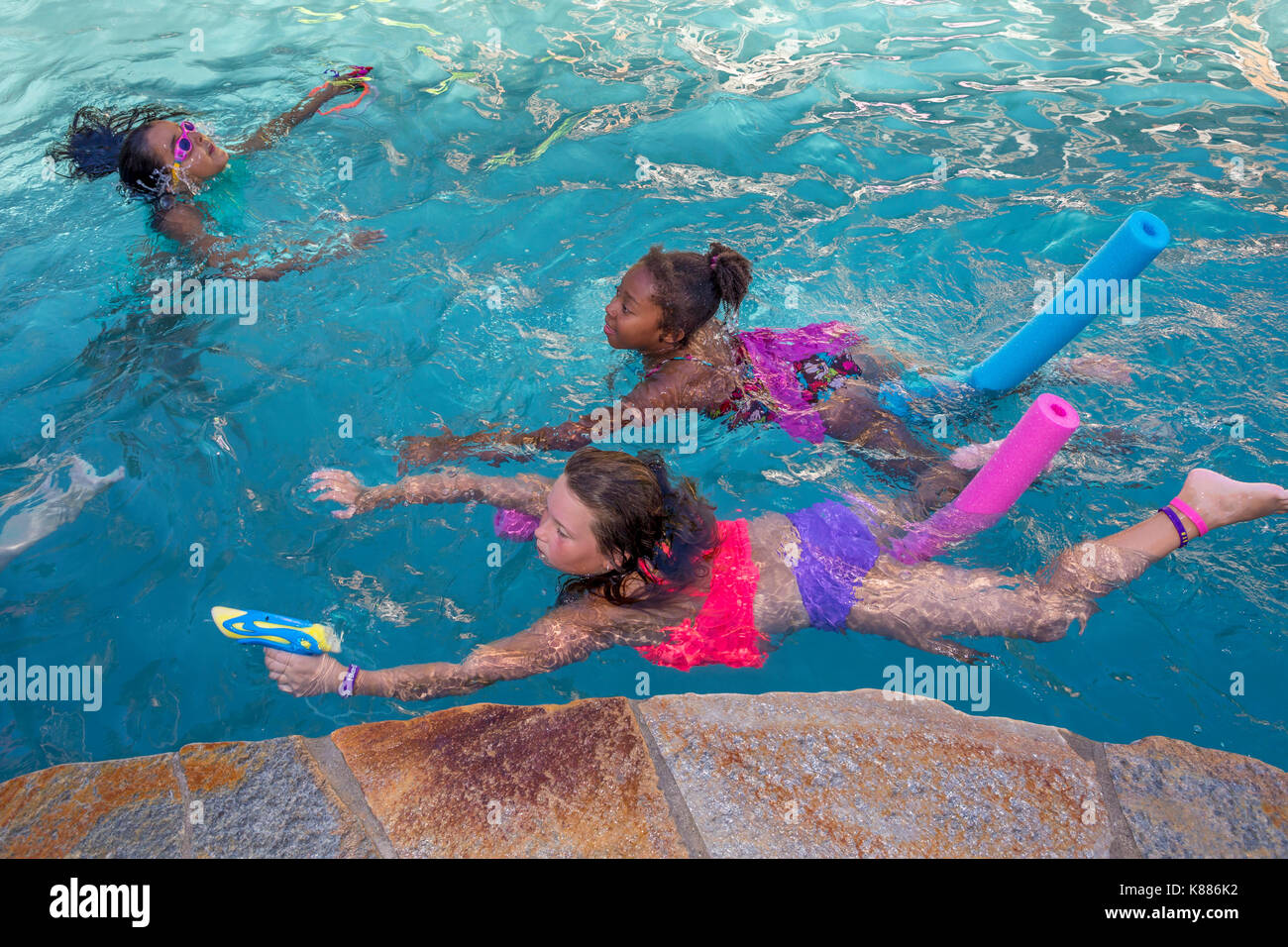 girls, children, playing, squirting water soaker, swimming pool, freshwater swimming pool, pool party, Castro Valley, Alameda County, California, Unit Stock Photo
