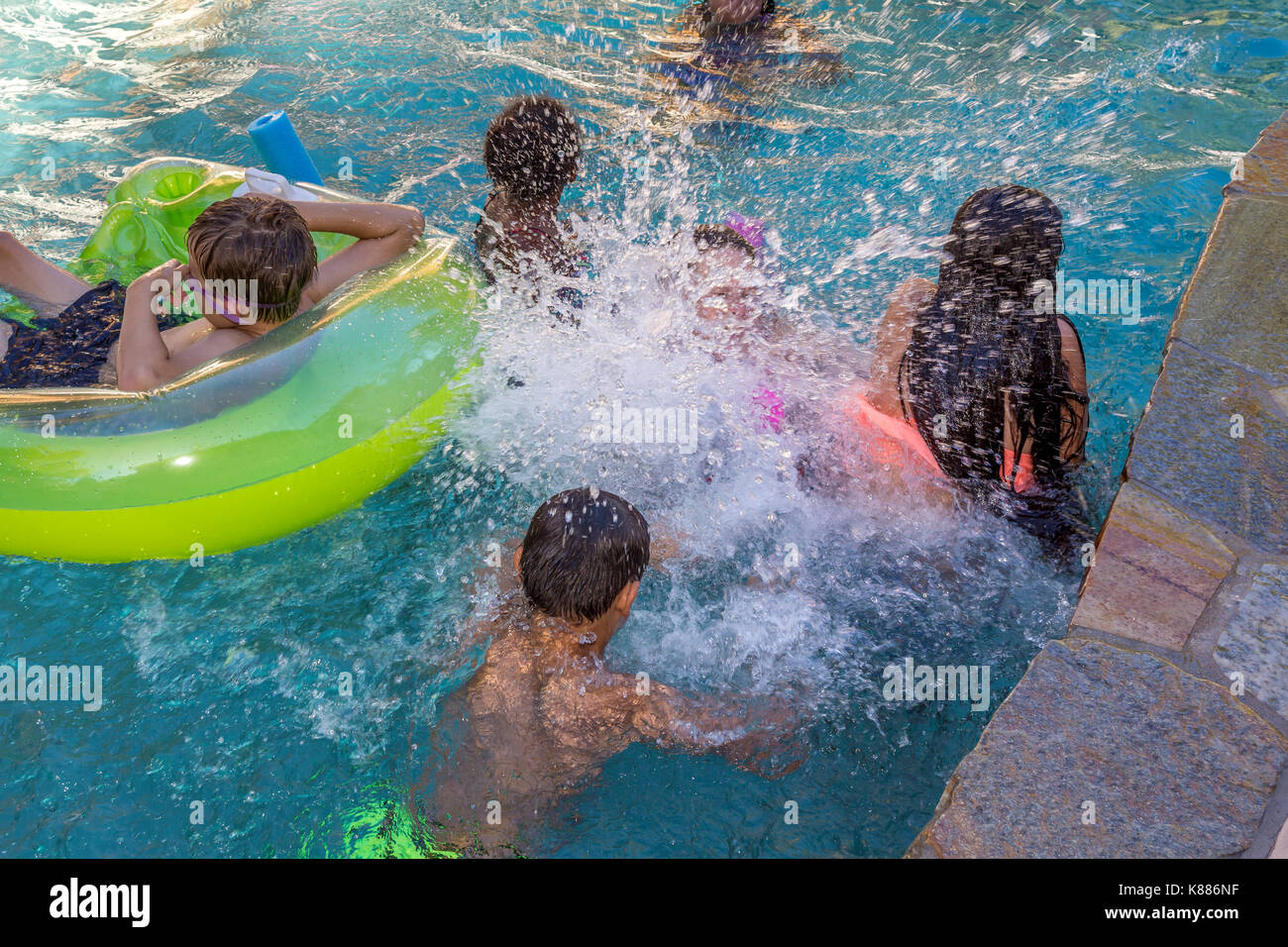 girls, boys, children, splashing one another, splashing water, freshwater swimming pool, pool party, Castro Valley, Alameda County, California Stock Photo