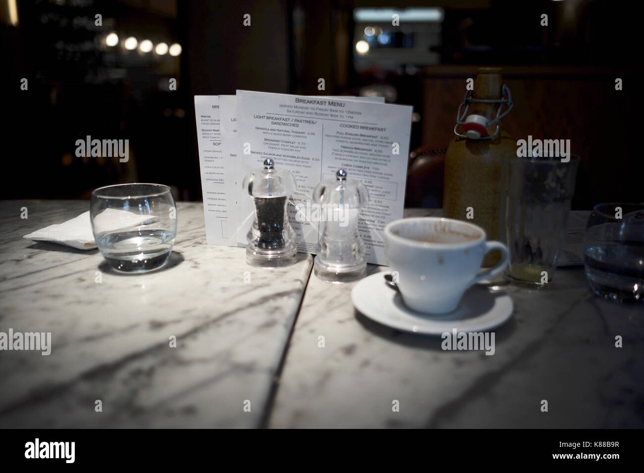 breakfast menu behind salt and pepper coffee cup and water glass on