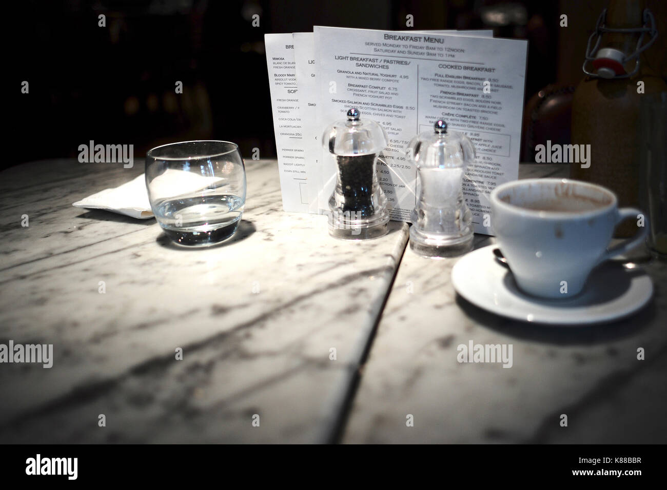 breakfast menu behind salt and pepper coffee cup and water glass on