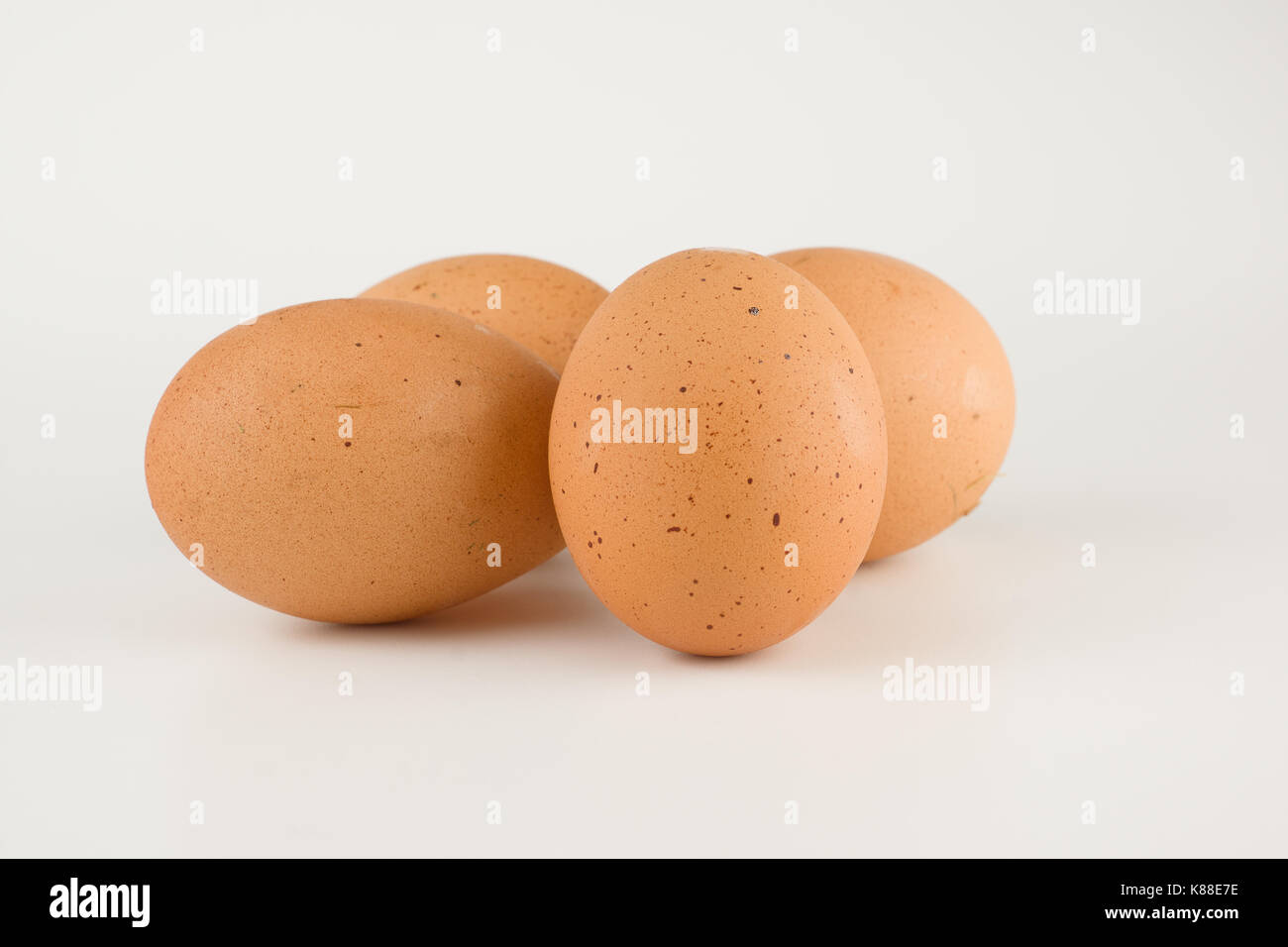 Four fresh rustic eggs isolated on white background Stock Photo