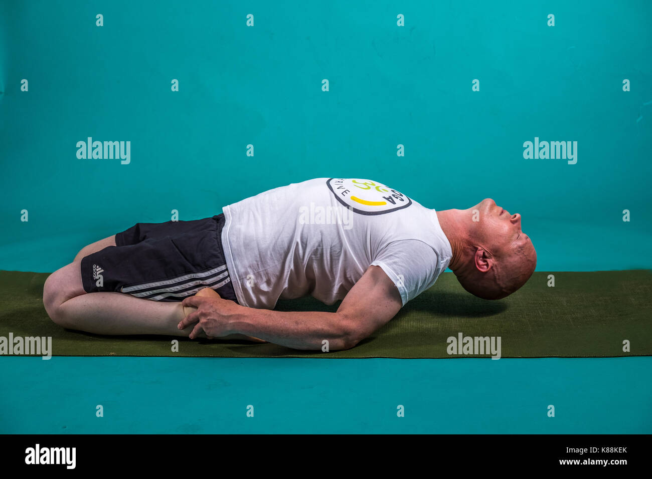 Yoga tutor going through some fitness moves Stock Photo