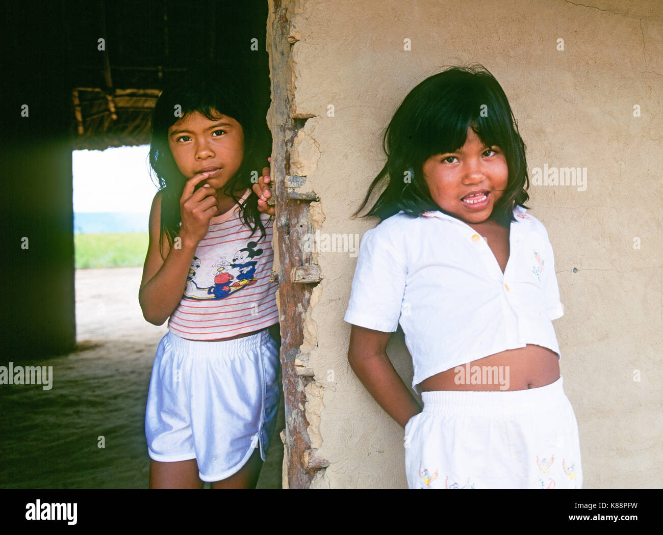 Two Pemon Indian girls wearing Western clothing given to them by tourists, in a remote rainforest village in the Grand Sabana forest region near Angel Stock Photo