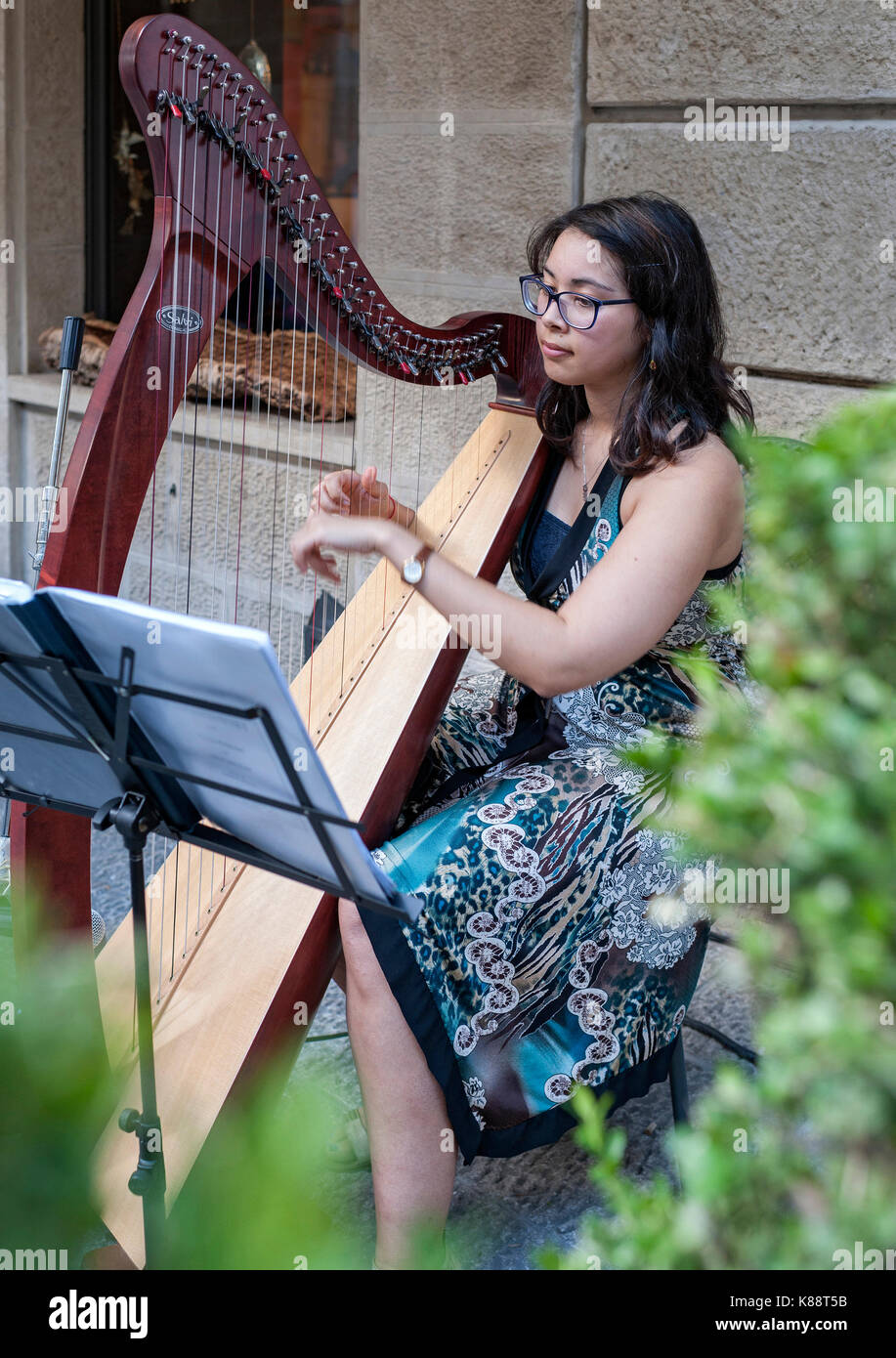 Harpist playing a harp in the old town in San Marino. Stock Photo