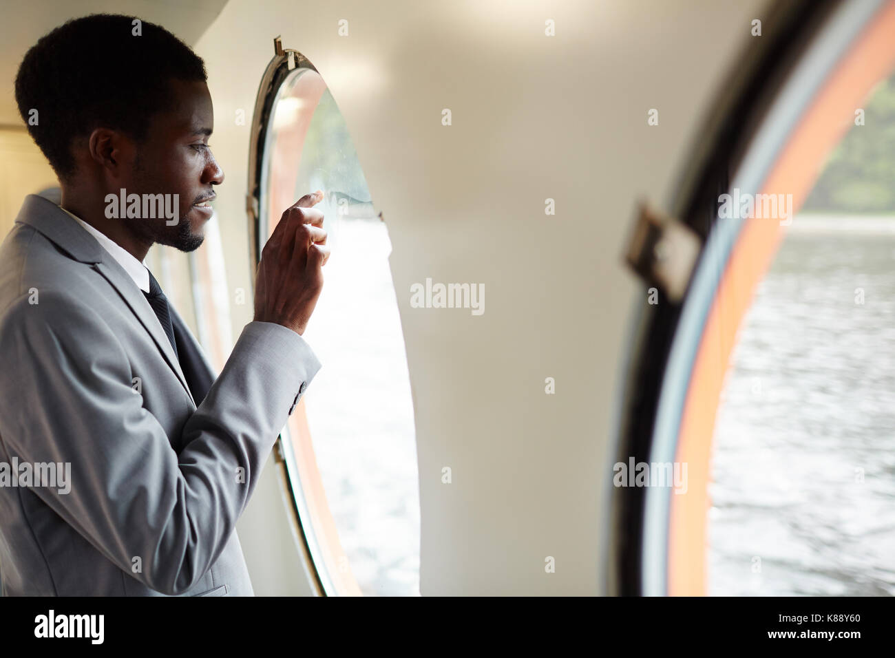 Young businessman in suit going to write something on steamship window Stock Photo