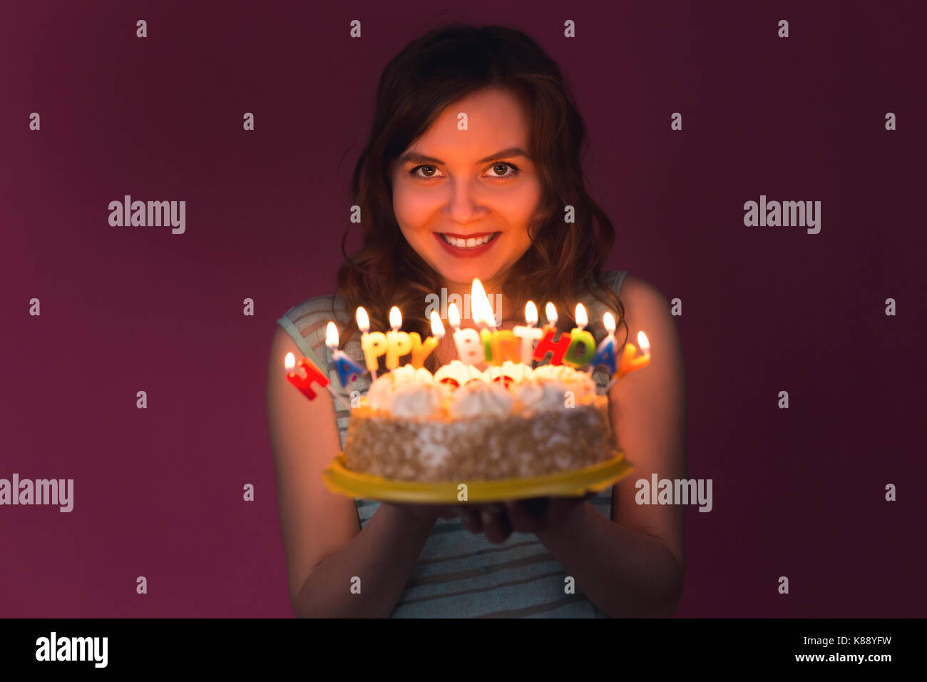 Portrait of pretty girl holding birthday cake at party Stock Photo - Alamy
