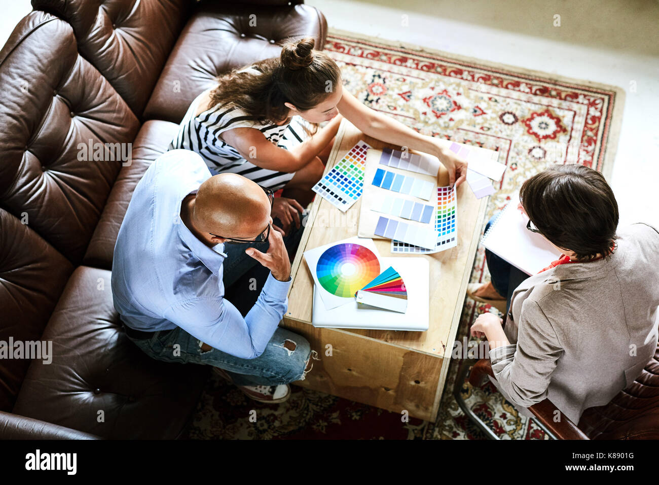 Top view of three designers discussing color palettes at start-up meeting Stock Photo