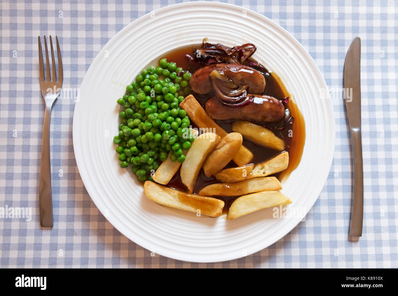Sausage chips and peas with onion gravy Stock Photo